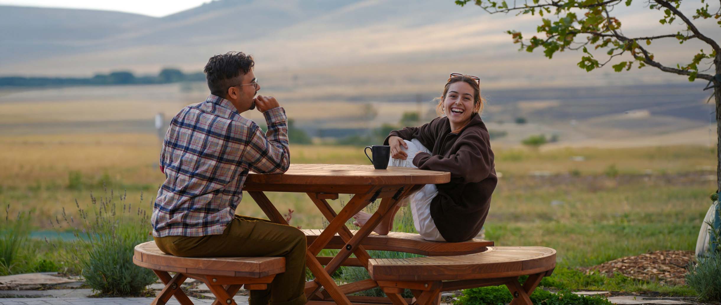 Two fellowship students joyfully conversing at a table at Namchak Retreat Ranch